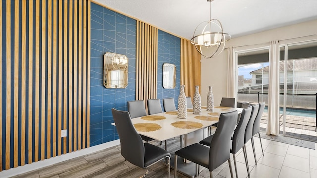 dining space featuring tile walls and a notable chandelier