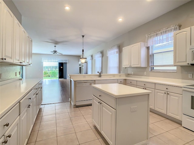 kitchen featuring pendant lighting, white appliances, white cabinetry, and a center island