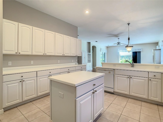 kitchen with white dishwasher, hanging light fixtures, a kitchen island, and white cabinets