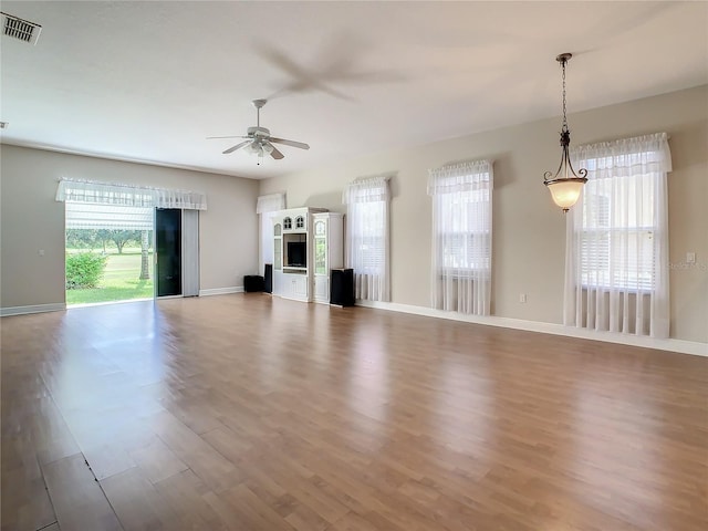 unfurnished living room with hardwood / wood-style flooring and ceiling fan