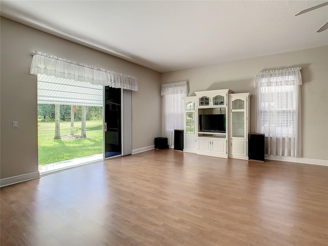 unfurnished living room with ceiling fan and light wood-type flooring