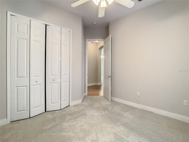 unfurnished bedroom with light carpet, a closet, and ceiling fan