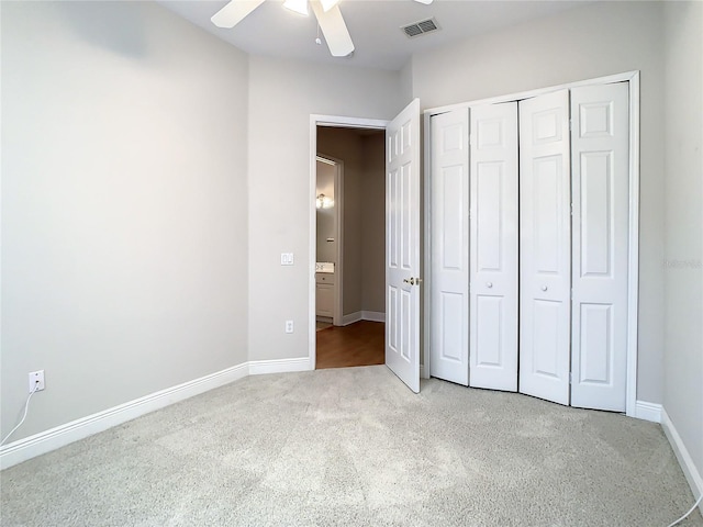 unfurnished bedroom featuring light carpet, a closet, and ceiling fan