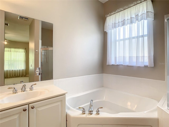 bathroom with vanity and shower with separate bathtub