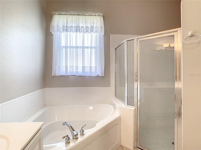 bathroom featuring vanity and independent shower and bath