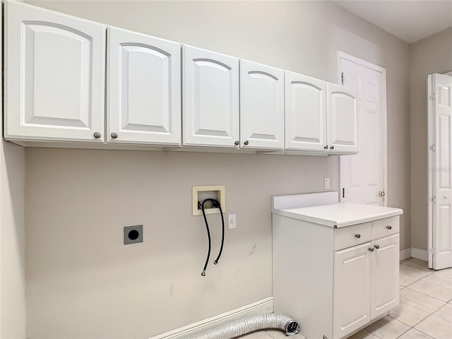 clothes washing area featuring cabinets, electric dryer hookup, washer hookup, and light tile patterned floors