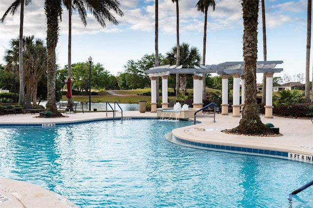 view of swimming pool with pool water feature, a pergola, and a patio area