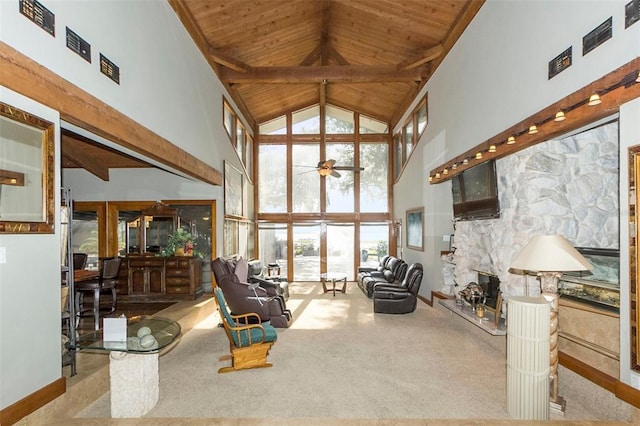 living area with a stone fireplace, high vaulted ceiling, and wooden ceiling