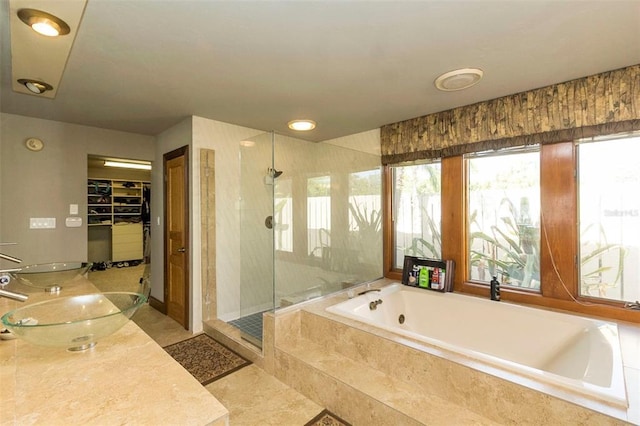 bathroom with tile flooring, separate shower and tub, and sink