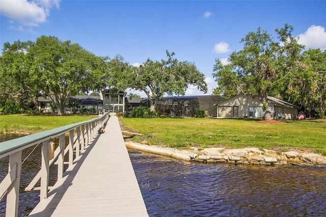 dock area with a lawn and a water view