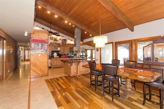 interior space featuring vaulted ceiling with beams, light wood-type flooring, and ceiling fan with notable chandelier