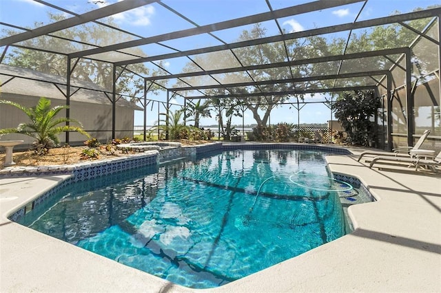 view of pool with a patio area and glass enclosure