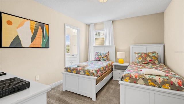 bedroom featuring ensuite bathroom and light carpet