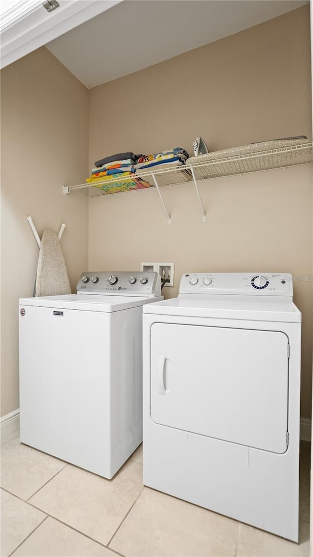 washroom with washing machine and dryer and light tile patterned floors