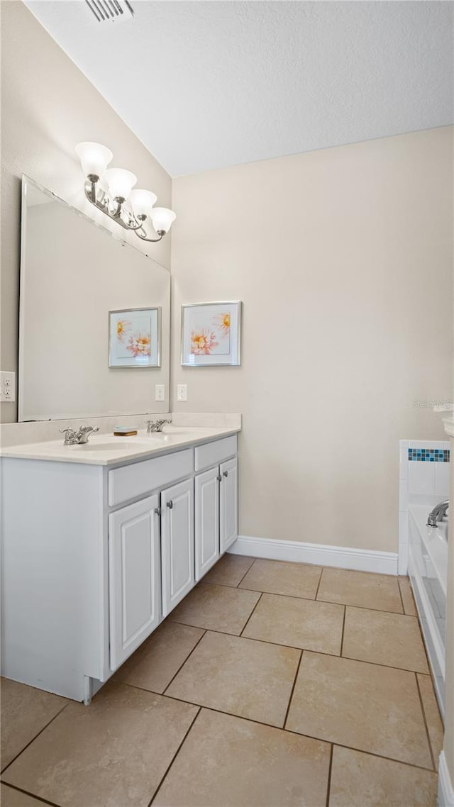 bathroom featuring vanity, a bath, and tile patterned floors