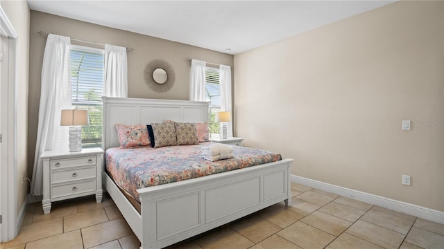 bedroom with multiple windows and light tile patterned floors