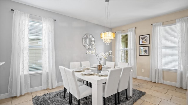 tiled dining area featuring a notable chandelier