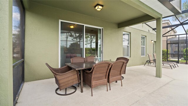 view of patio featuring glass enclosure