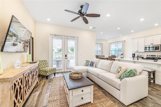 living room featuring french doors, a wealth of natural light, ceiling fan, and light hardwood / wood-style flooring