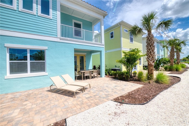 back of house featuring a balcony and a patio