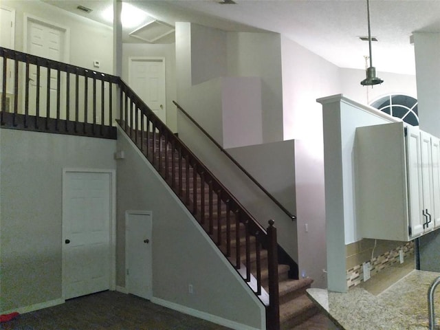 staircase featuring dark colored carpet