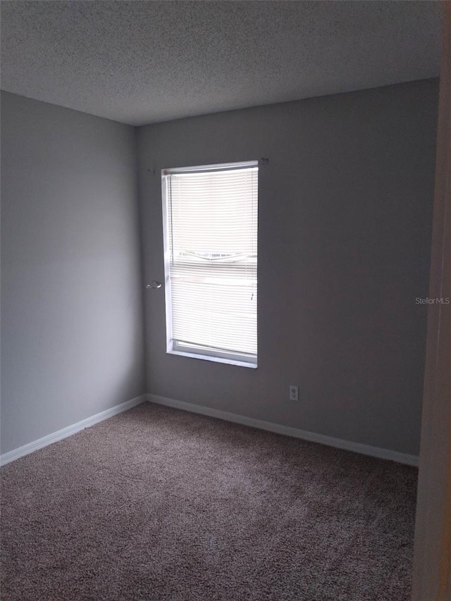 carpeted spare room featuring a textured ceiling