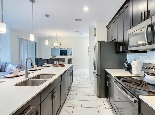 kitchen featuring sink, decorative light fixtures, and appliances with stainless steel finishes