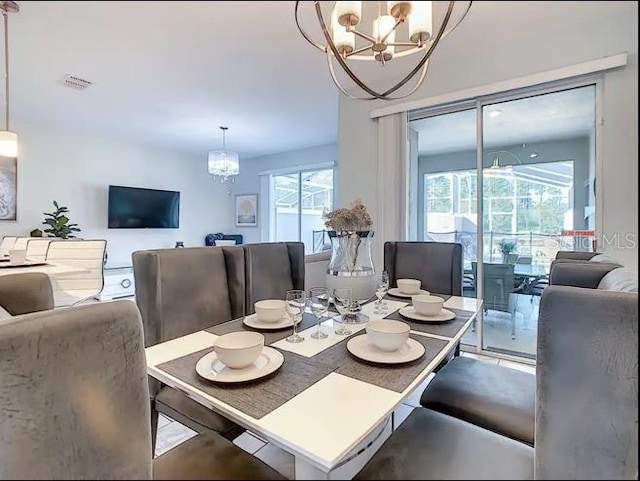 dining room featuring plenty of natural light and a notable chandelier