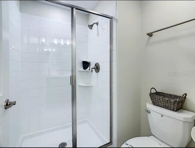 bathroom with an enclosed shower and toilet