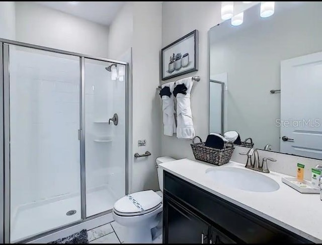 bathroom featuring tile patterned floors, toilet, vanity, and walk in shower