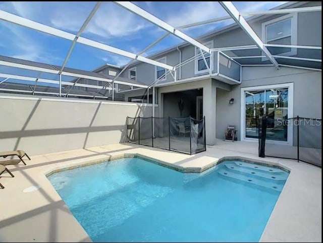 view of pool with a patio and glass enclosure