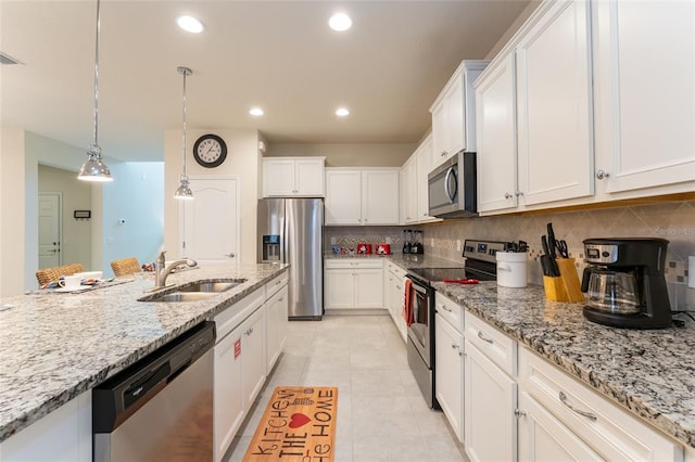 kitchen featuring stainless steel appliances, decorative light fixtures, light tile flooring, white cabinets, and sink