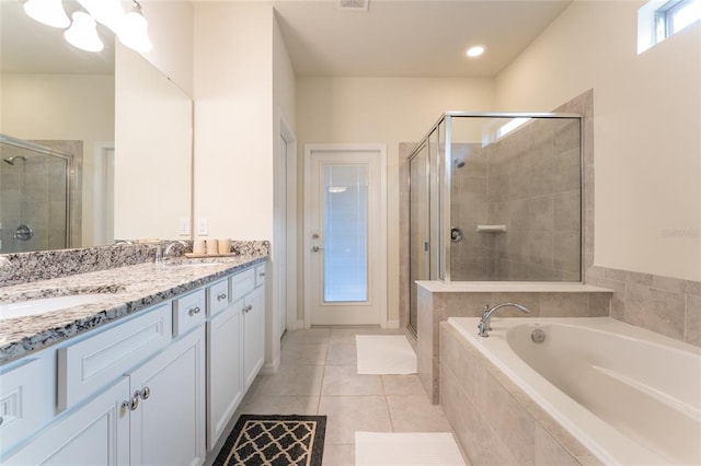 bathroom featuring double vanity, separate shower and tub, and tile flooring