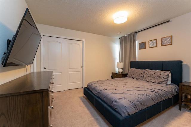 carpeted bedroom featuring a closet and a textured ceiling