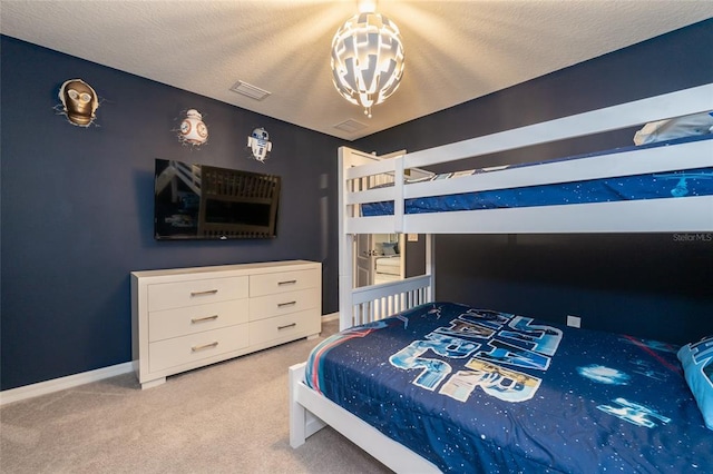 carpeted bedroom featuring a textured ceiling and an inviting chandelier