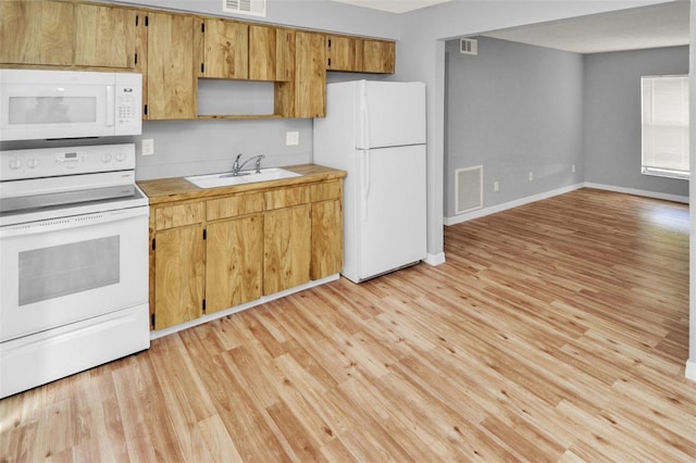 kitchen with sink, white appliances, and light hardwood / wood-style floors