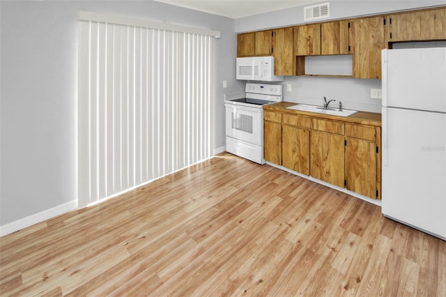 kitchen with sink, white appliances, and light hardwood / wood-style floors