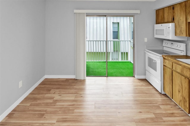 kitchen with white appliances, plenty of natural light, and light hardwood / wood-style floors