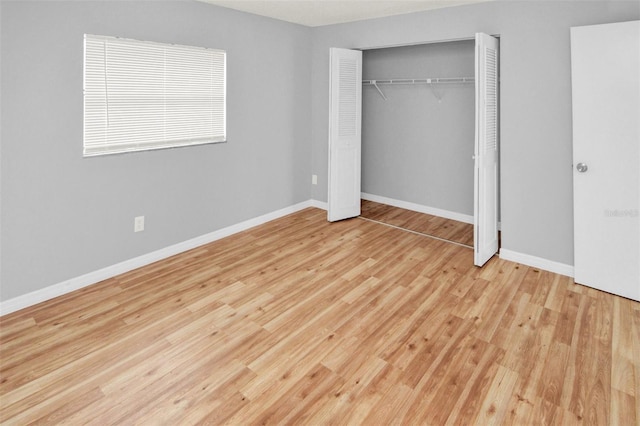 unfurnished bedroom featuring light hardwood / wood-style floors and a closet