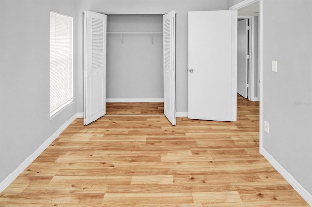 unfurnished bedroom featuring light wood-type flooring and a closet