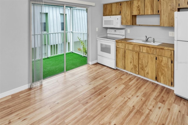 kitchen featuring sink, white appliances, and light hardwood / wood-style flooring