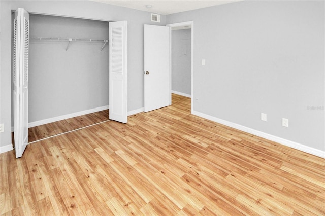 unfurnished bedroom featuring a closet and light hardwood / wood-style flooring