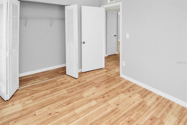 unfurnished bedroom featuring light hardwood / wood-style floors and a closet