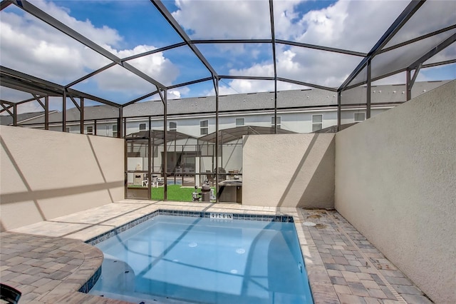 view of swimming pool featuring a patio and glass enclosure