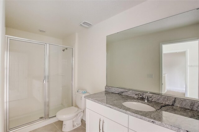 bathroom with vanity, an enclosed shower, toilet, and tile patterned flooring