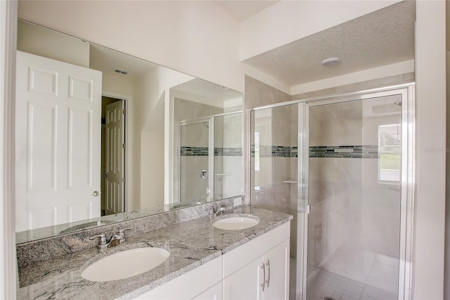 bathroom featuring vanity, walk in shower, a textured ceiling, and tile patterned flooring