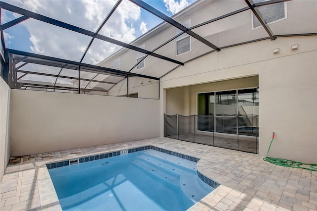 view of swimming pool featuring a patio area and glass enclosure