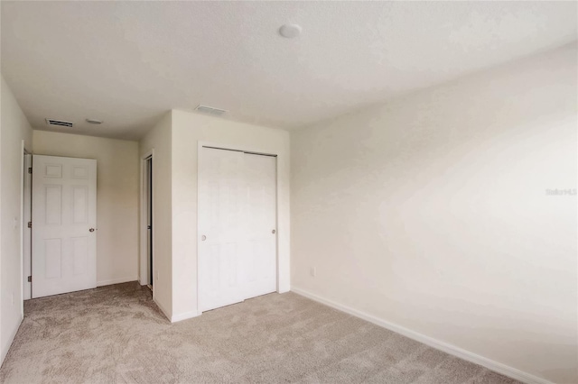 unfurnished bedroom featuring light carpet