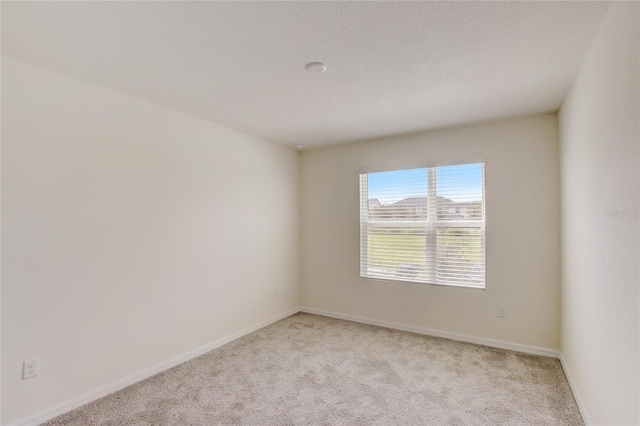 carpeted empty room featuring a textured ceiling