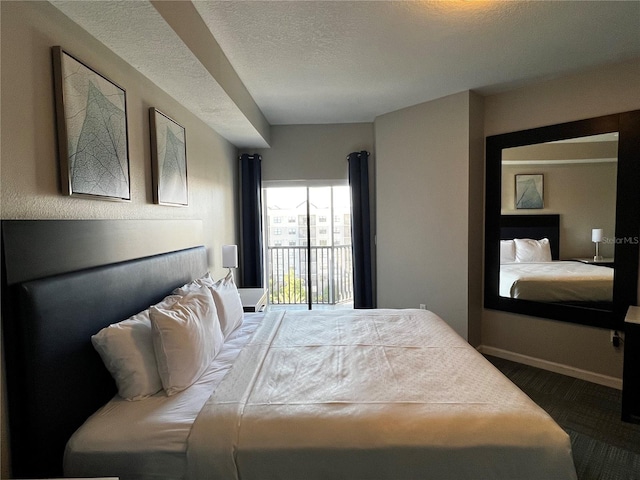 carpeted bedroom with a textured ceiling and access to exterior